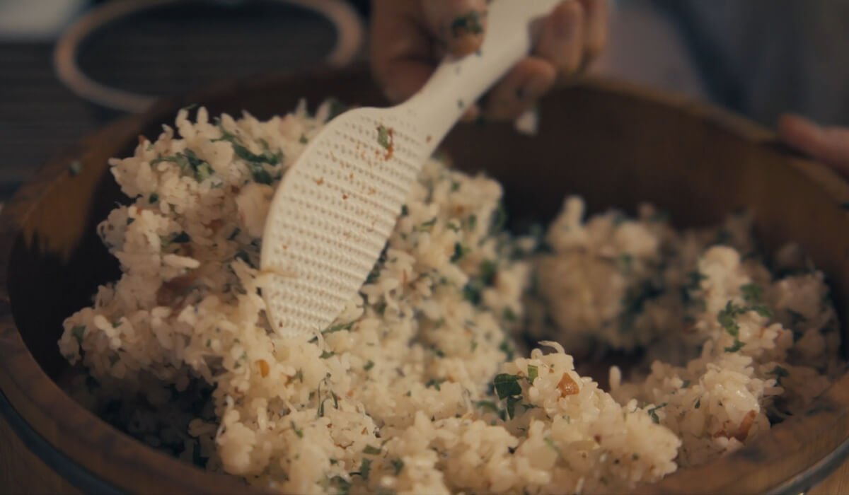 Krupan plan pripreme kuvane kinoe sa začinskim biljem u drvenoj posudi.